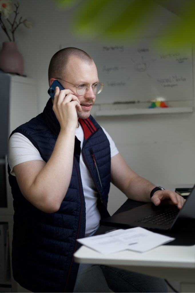 Mann mit kurzen Haaren und einem iPhone am Ohr