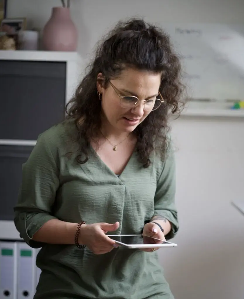 Frau mit Locken und einem Ipad in der Hand