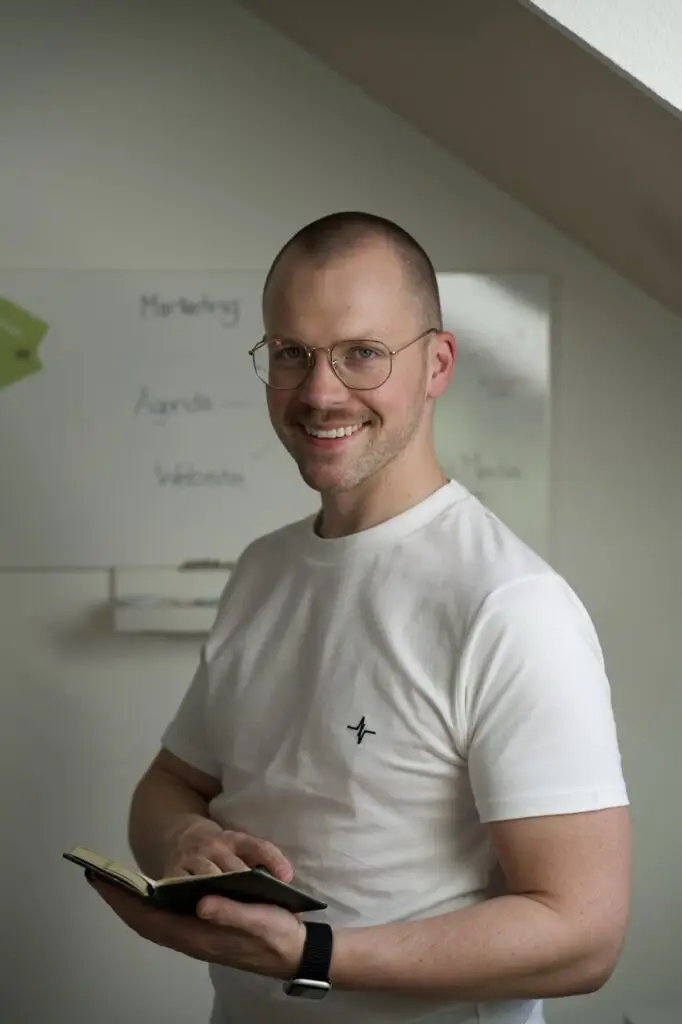 Mann mit kurzen Haaren und einem Buch in der Hand