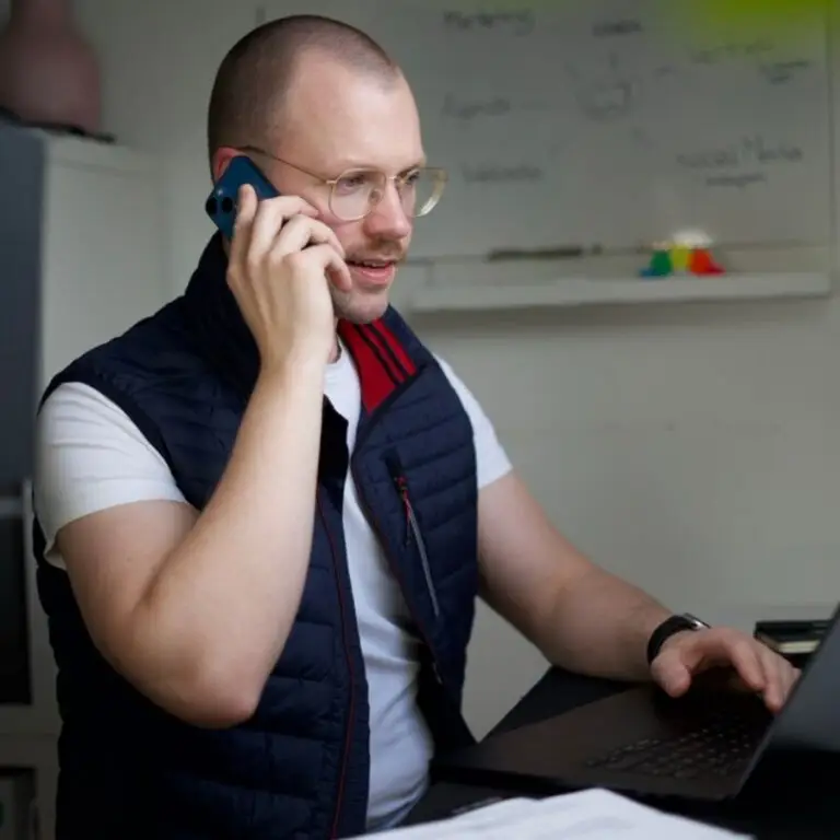 Mann mit kurzen Haaren und einem iPhone am Ohr